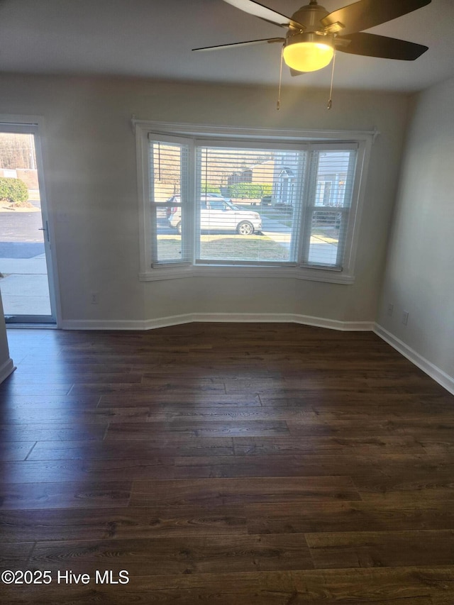 spare room featuring ceiling fan, a healthy amount of sunlight, and dark hardwood / wood-style floors