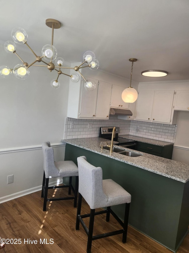 kitchen featuring decorative light fixtures, light stone countertops, kitchen peninsula, and white cabinets