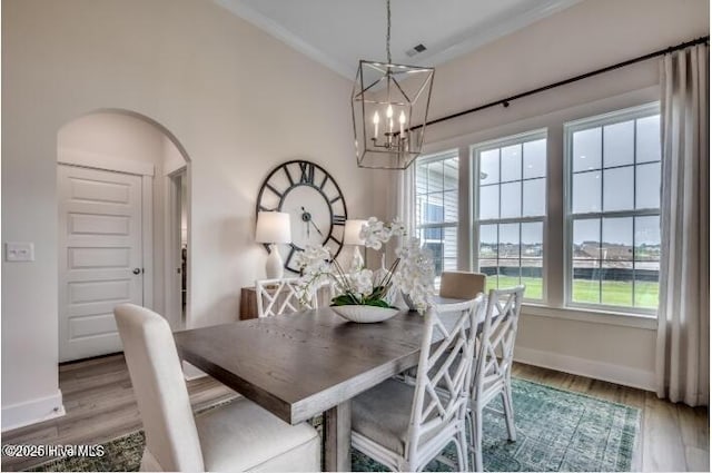 dining space featuring lofted ceiling, hardwood / wood-style floors, and an inviting chandelier