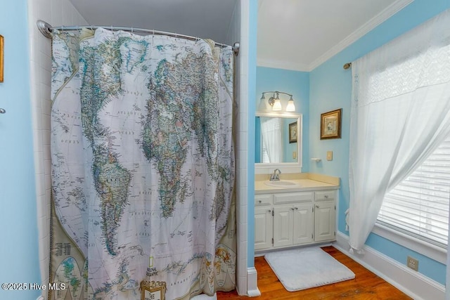 bathroom featuring vanity, hardwood / wood-style floors, a shower with curtain, and ornamental molding