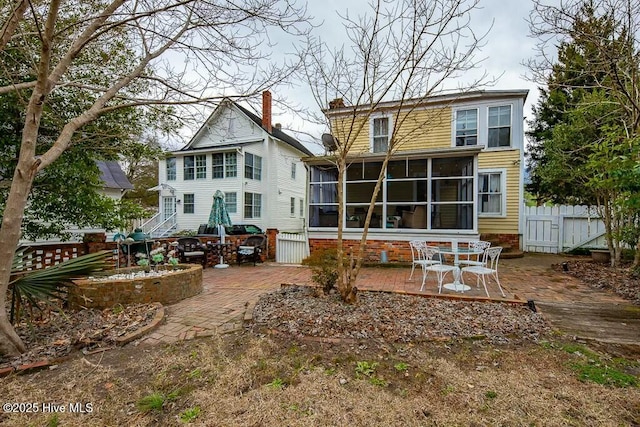 back of property with a patio area and a sunroom