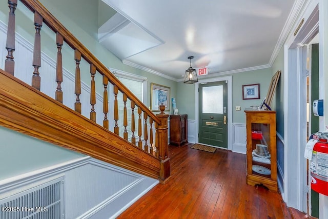 entrance foyer with ornamental molding and dark hardwood / wood-style floors