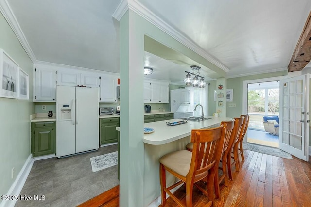 kitchen featuring crown molding, white cabinets, and white fridge with ice dispenser