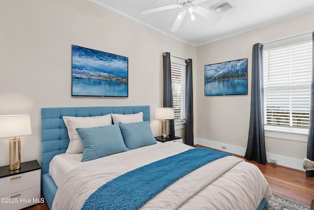 bedroom featuring ceiling fan, ornamental molding, and hardwood / wood-style floors