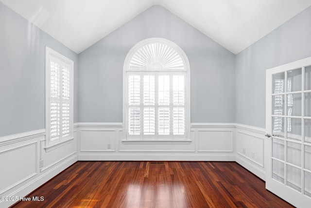 unfurnished room with vaulted ceiling, plenty of natural light, and dark hardwood / wood-style flooring