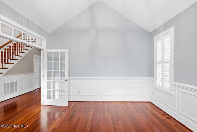 empty room with lofted ceiling and dark hardwood / wood-style flooring