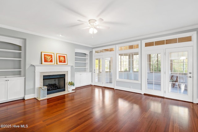 unfurnished living room with built in shelves, dark wood-type flooring, and ornamental molding