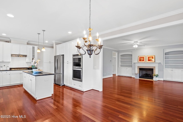 kitchen featuring stainless steel appliances, white cabinetry, hanging light fixtures, and a center island