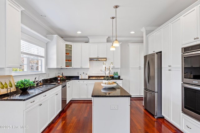 kitchen with decorative light fixtures, sink, dark stone countertops, a center island, and stainless steel appliances