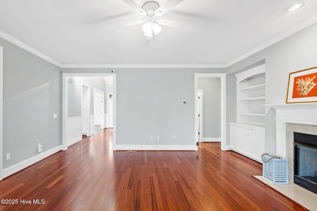 unfurnished living room with built in shelves, ceiling fan, ornamental molding, and dark hardwood / wood-style flooring