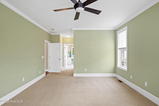 carpeted spare room with ceiling fan and ornamental molding