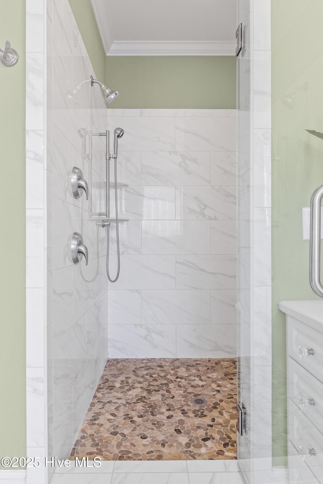 bathroom featuring crown molding and a shower with door