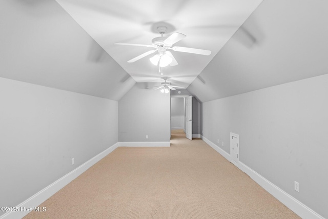 bonus room with vaulted ceiling, light colored carpet, and ceiling fan