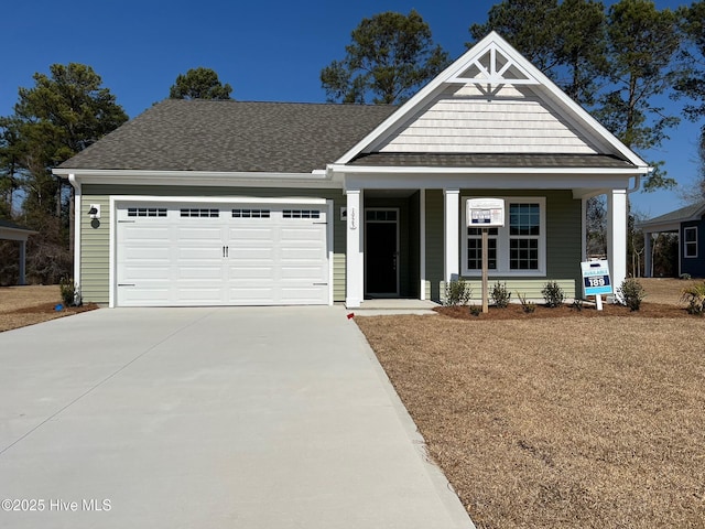 view of front of property with a garage, driveway, and roof with shingles