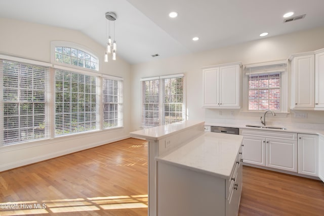 kitchen with sink, hanging light fixtures, and white cabinets