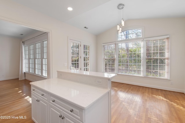 kitchen featuring white cabinetry, a kitchen island, pendant lighting, and light hardwood / wood-style floors