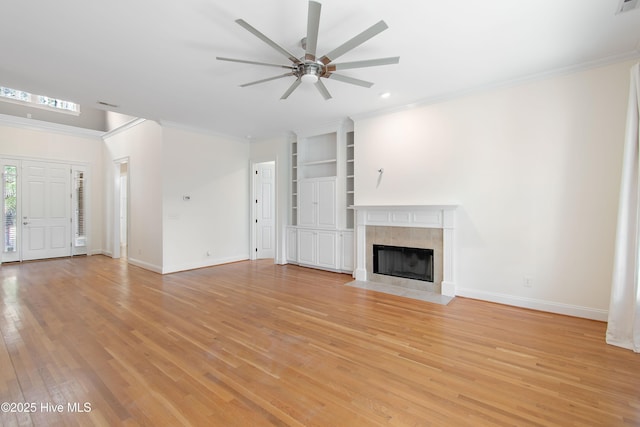 unfurnished living room featuring crown molding, ceiling fan, a fireplace, and light hardwood / wood-style flooring