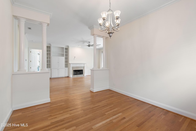 unfurnished living room featuring ornate columns, crown molding, ceiling fan with notable chandelier, and light hardwood / wood-style floors