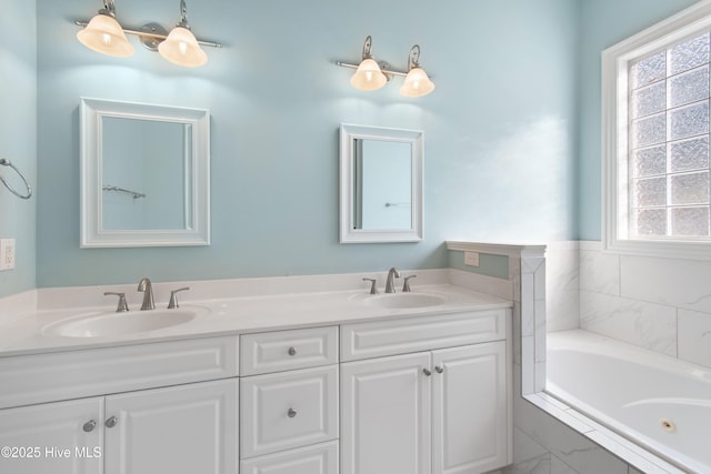 bathroom with vanity, tiled bath, and a wealth of natural light