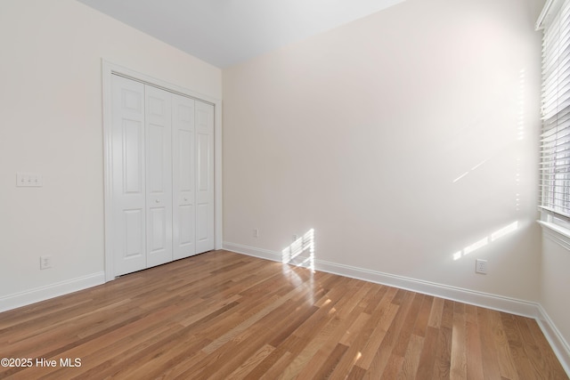 unfurnished bedroom featuring hardwood / wood-style flooring and a closet