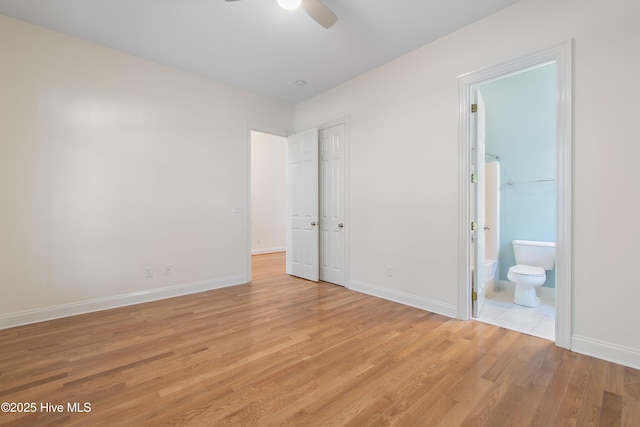 unfurnished bedroom featuring ceiling fan, ensuite bathroom, and light hardwood / wood-style flooring