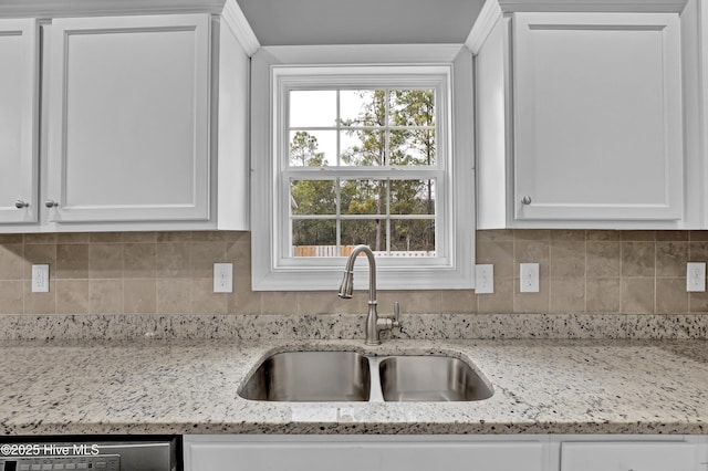 kitchen featuring white cabinetry, light stone countertops, sink, and decorative backsplash