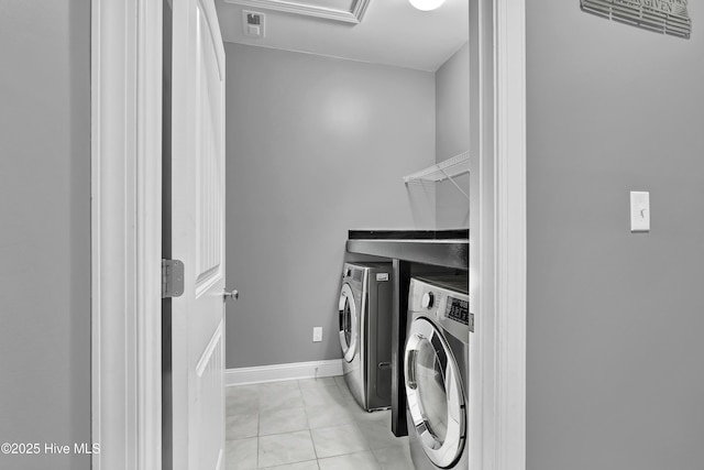 clothes washing area featuring separate washer and dryer and light tile patterned floors