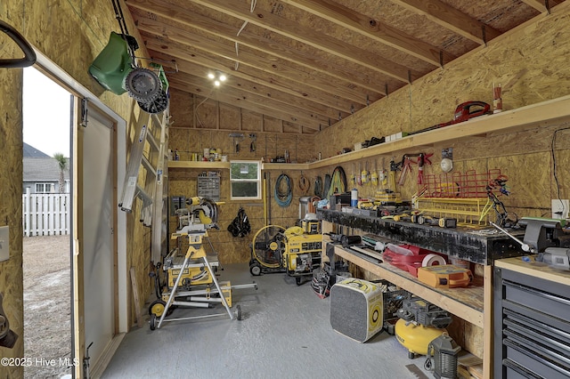 miscellaneous room with vaulted ceiling and a workshop area