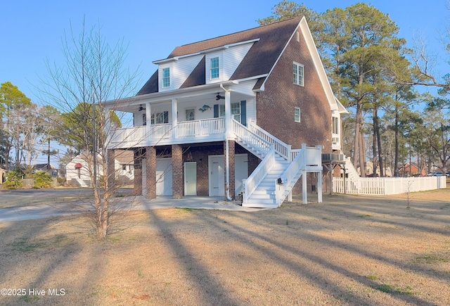 view of front of house with ceiling fan, a garage, covered porch, and a front lawn