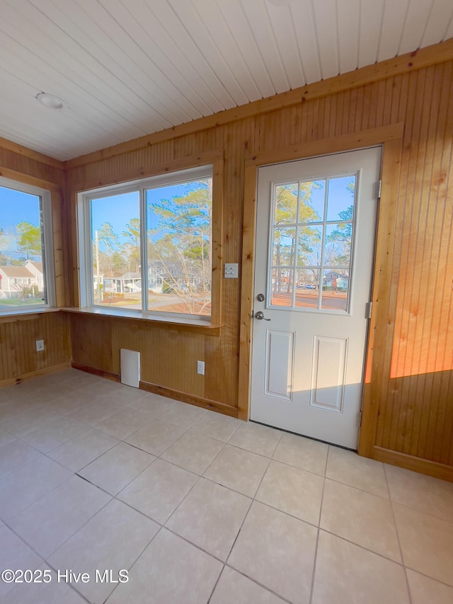 interior space featuring light tile patterned flooring and wooden walls