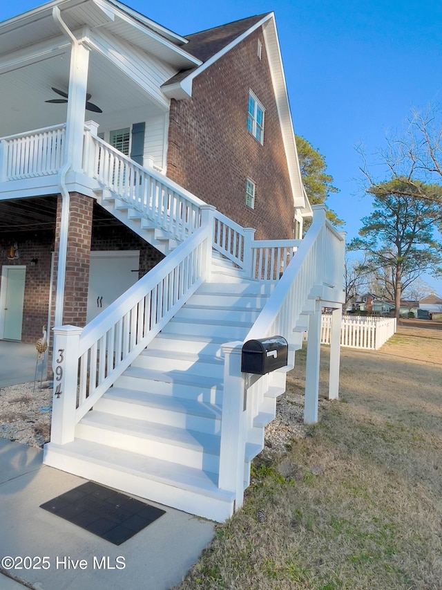 view of side of home with covered porch and a lawn