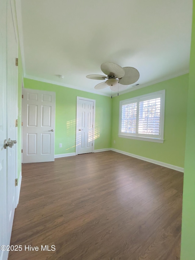 unfurnished room featuring dark hardwood / wood-style flooring, crown molding, and ceiling fan