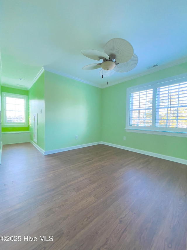 empty room with ornamental molding, dark wood-type flooring, and ceiling fan