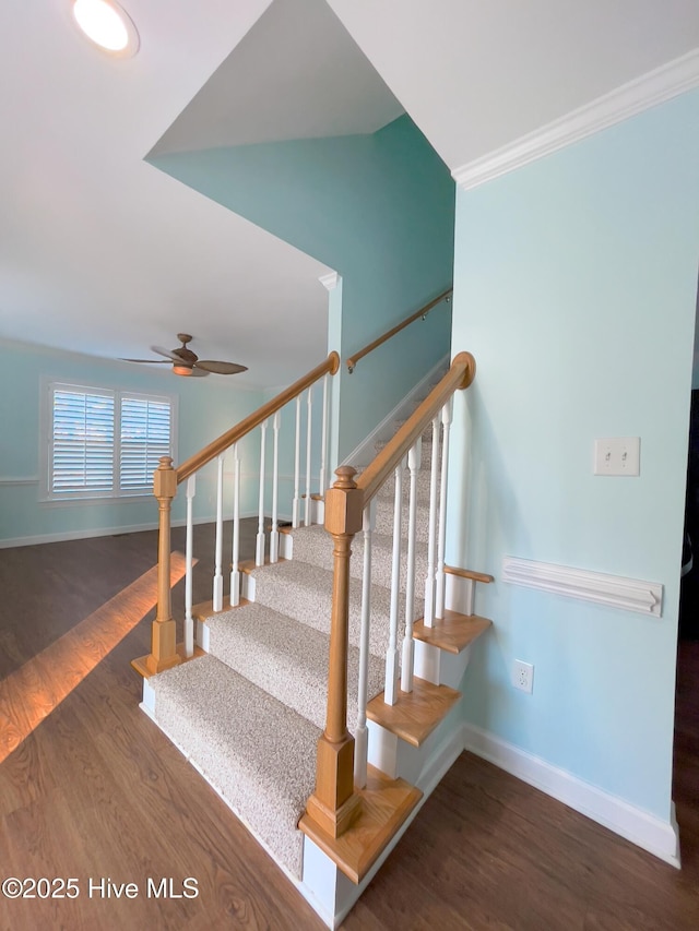 stairway with crown molding, wood-type flooring, and ceiling fan