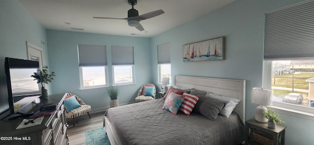 bedroom featuring multiple windows, ceiling fan, and light hardwood / wood-style flooring