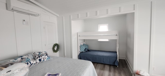 bedroom featuring dark hardwood / wood-style flooring, a wall mounted air conditioner, and crown molding