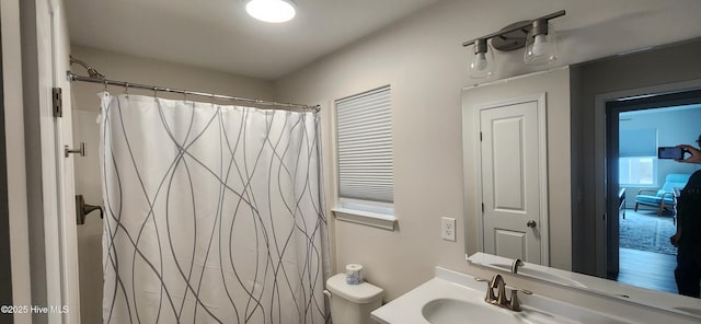 bathroom featuring vanity, curtained shower, and toilet