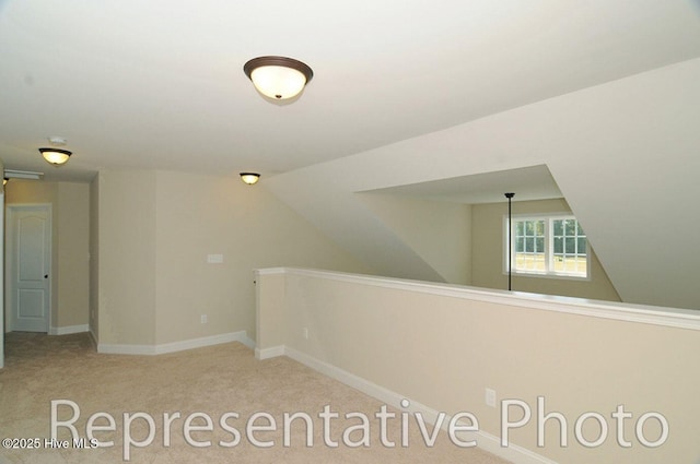 hallway featuring light carpet and vaulted ceiling