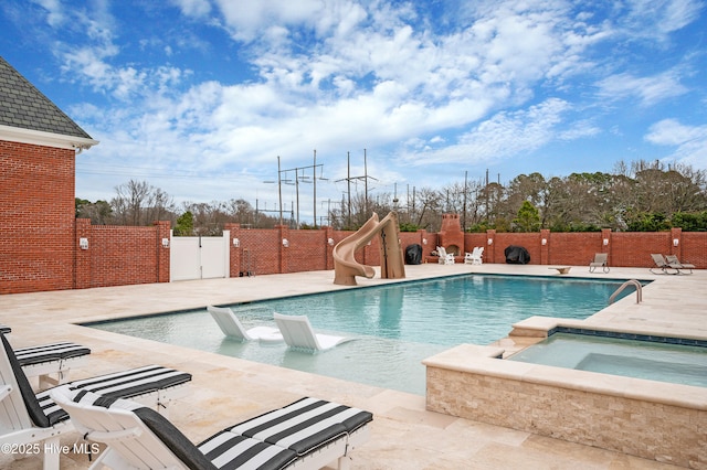 view of pool featuring an in ground hot tub, a water slide, and a patio area