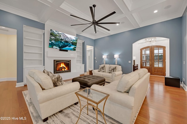 living room featuring coffered ceiling, beam ceiling, light hardwood / wood-style floors, and french doors