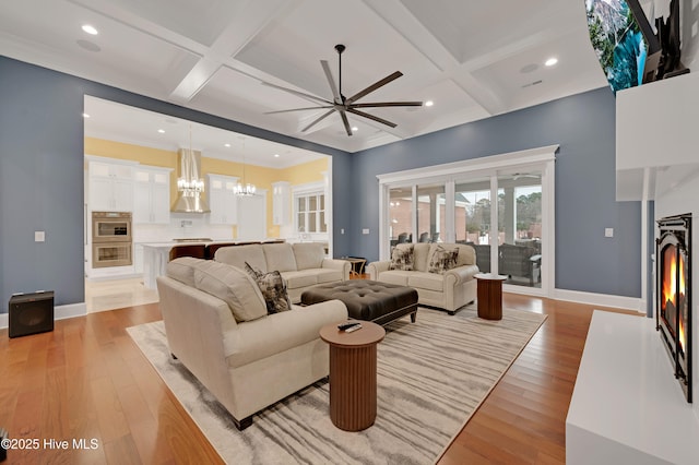 living room with beamed ceiling, coffered ceiling, and light hardwood / wood-style floors