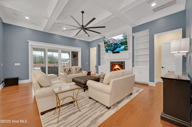 living room featuring light hardwood / wood-style flooring, ceiling fan, beam ceiling, coffered ceiling, and ornamental molding