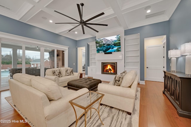 living room with coffered ceiling, beam ceiling, and light hardwood / wood-style flooring