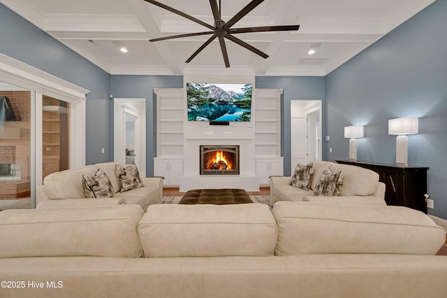 living room featuring beamed ceiling, coffered ceiling, and a large fireplace