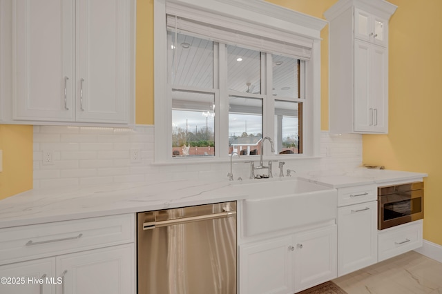 kitchen featuring light stone countertops, white cabinets, and appliances with stainless steel finishes