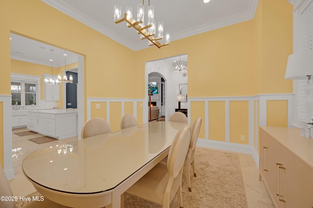 dining space with ornamental molding and a chandelier