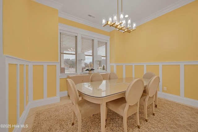 tiled dining space with a notable chandelier and ornamental molding