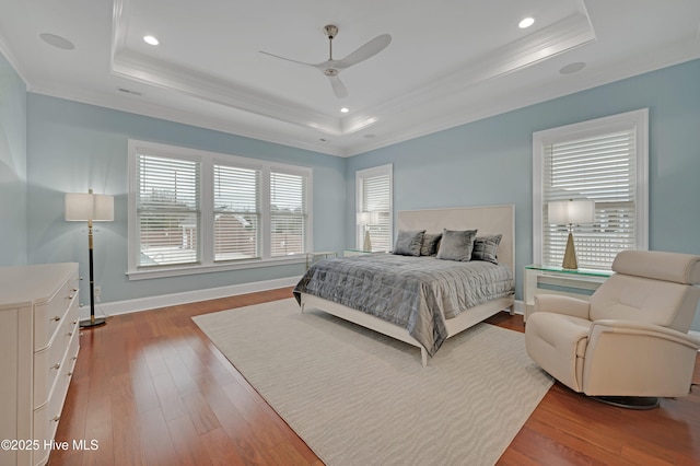 bedroom featuring a raised ceiling, wood-type flooring, ceiling fan, and crown molding