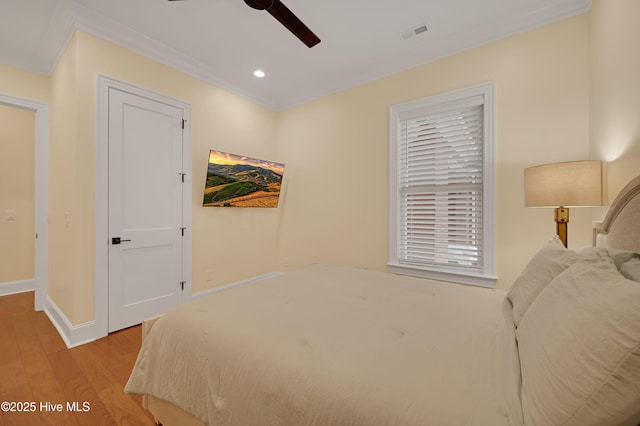 bedroom featuring ornamental molding, ceiling fan, and light hardwood / wood-style floors