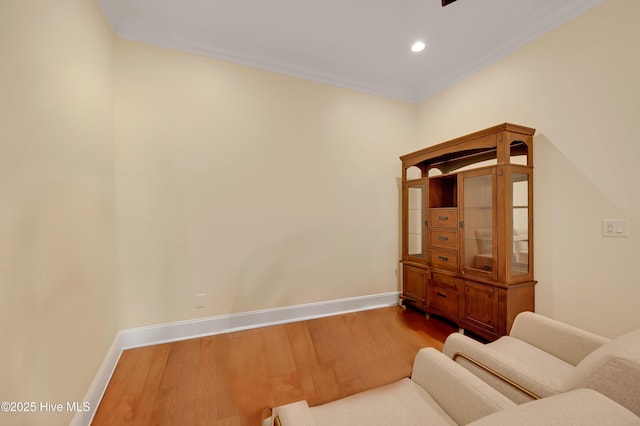 sitting room with hardwood / wood-style flooring and ornamental molding